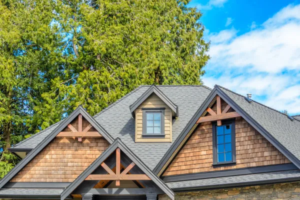 Modern Rustic Cedar Shake home with view of gables and Gray Shingle roof.