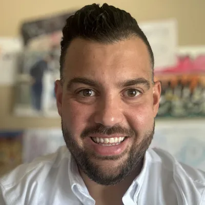 Tony Torres, Co-Owner. Headshot in white polo at home